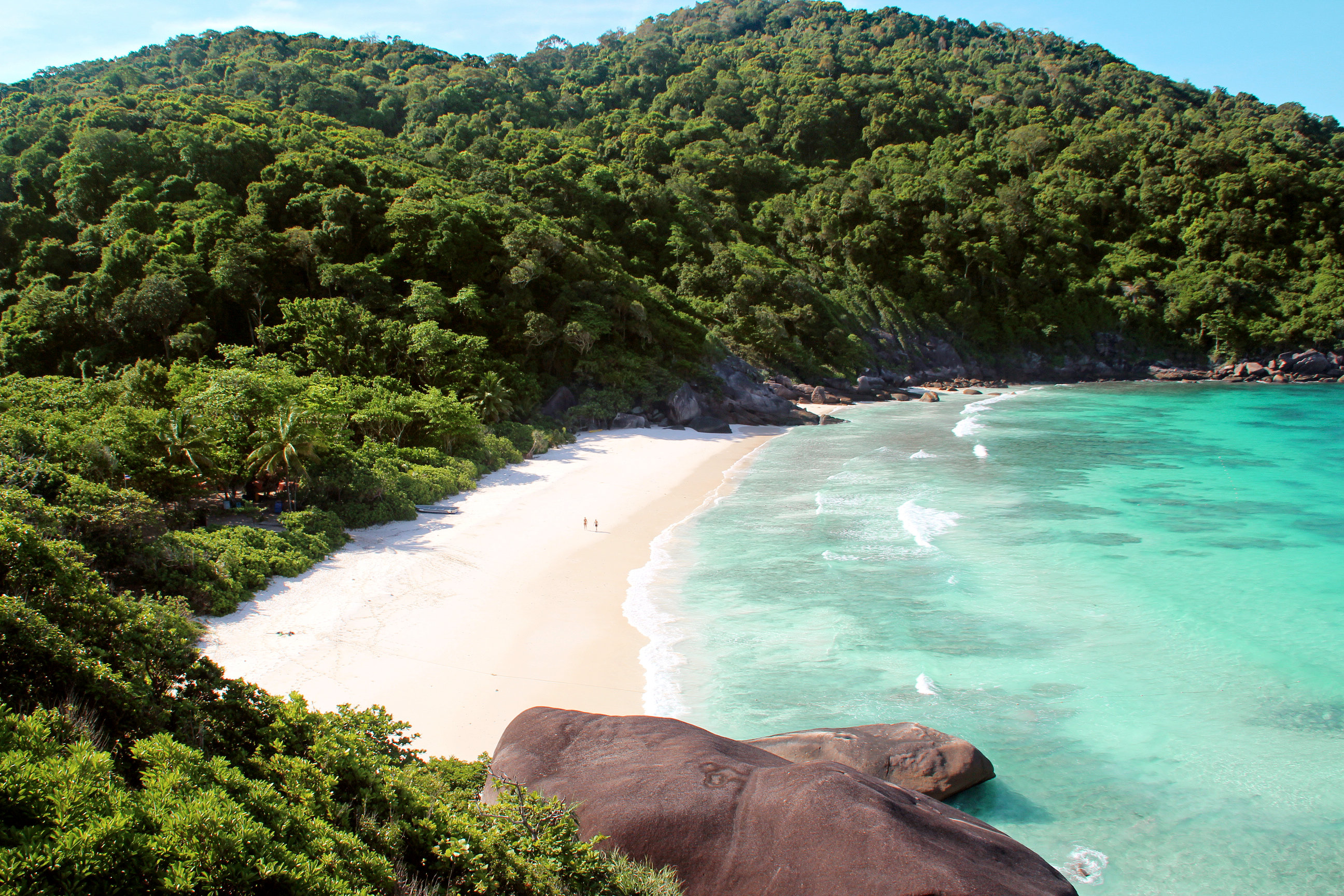 Verlaten zandstrand omgeven door tropische bossen nabij beach resort in Phuket, Thailand